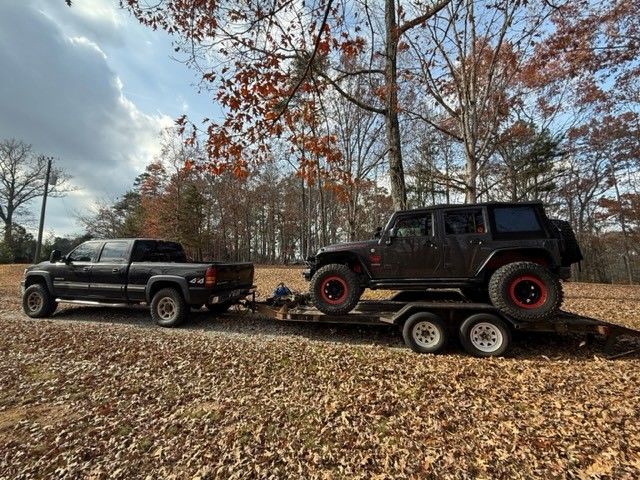 Truck towing Jeep in forest with Mac's straps